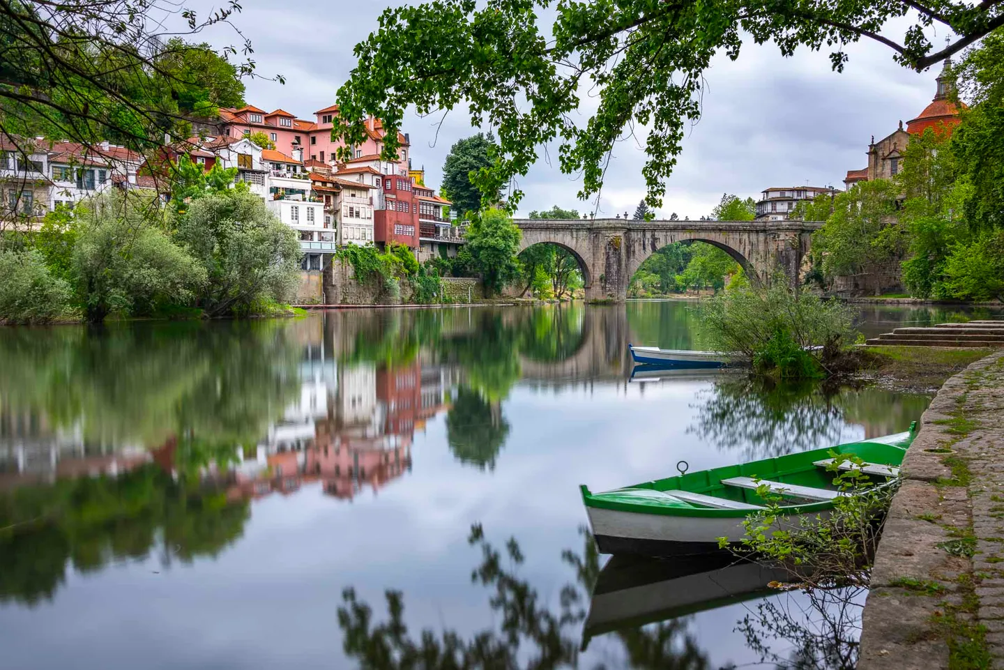 Amarante and its stone bridge reflected in the calm Tâmega River.