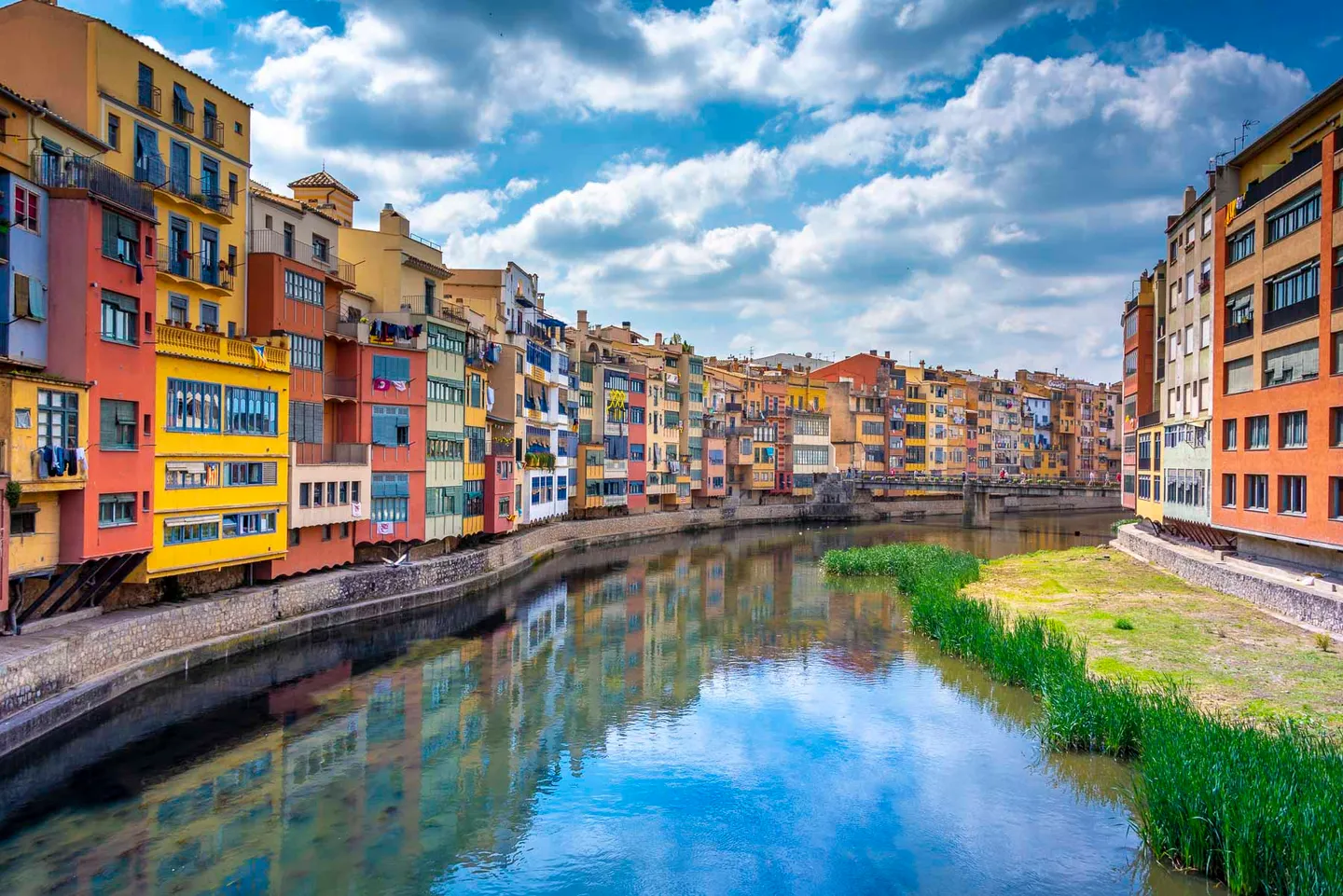 The colorful houses of Girona reflected in the Onyar River.